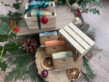 Natural, handmade soap bars in a wooden crate with Christmas ribbon, tag and bauble.
