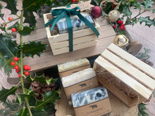 Natural, handmade soap bars in a wooden crate with Christmas ribbon, tag and bauble.