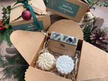 Gift set with natural handmade soap and aromatherapy shower steamers in a decorative box with Christmas-themed elements.