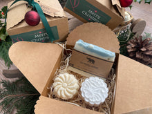 Gift set with natural handmade soap and aromatherapy shower steamers in a decorative box with Christmas-themed elements.