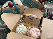 Gift set with natural handmade soap and aromatherapy shower steamers in a decorative box with Christmas-themed elements.