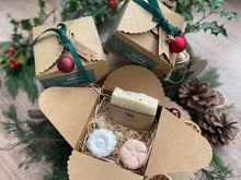 Gift set with natural handmade soap and aromatherapy shower steamers in a decorative box with Christmas-themed elements.
