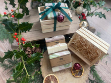 Natural, handmade soap bars in a wooden crate with Christmas ribbon, tag and bauble.