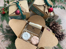 Gift set with natural handmade soap and aromatherapy shower steamers in a decorative box with Christmas-themed elements.