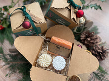 Gift set with natural handmade soap and aromatherapy shower steamers in a decorative box with Christmas-themed elements.