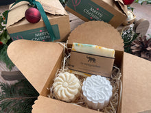 Gift set with natural handmade soap and aromatherapy shower steamers in a decorative box with Christmas-themed elements.