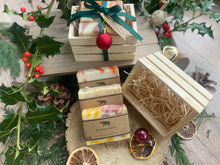 Natural, handmade soap bars in a wooden crate with Christmas ribbon, tag and bauble.