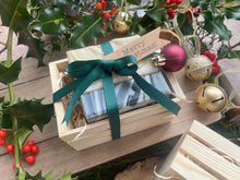 Natural, handmade soap bars in a wooden crate with Christmas ribbon, tag and bauble.