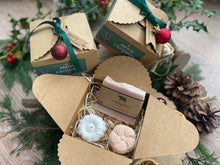 Gift set with natural handmade soap and aromatherapy shower steamers in a decorative box with Christmas-themed elements.