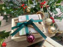 Natural, handmade soap bars in a wooden crate with Christmas ribbon, tag and bauble.